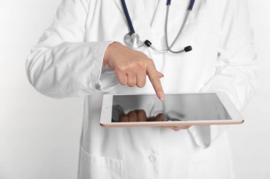 Beyaz arkaplanda tablet kullanan doktor, görüntüyü kapat