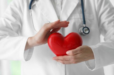 Klinikte kırmızı kalpli bir doktor, yakın plan.