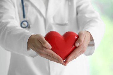 Klinikte kırmızı kalpli bir doktor, yakın plan.