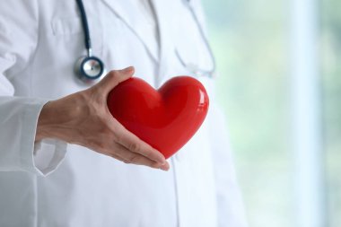 Klinikte kırmızı kalpli bir doktor, yakın plan. Metin için boşluk