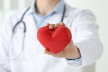 Kapalı alanda kırmızı kalbi olan doktor, seçici odaklanma