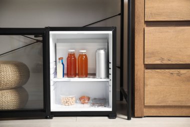 Farklı içecekler ve atıştırmalıklarla dolu mini buzdolabı.