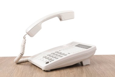 Telefon ahşap masada, arka planda.