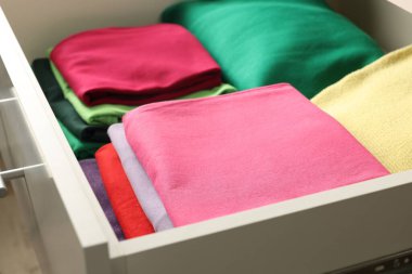 Farklı katlanmış elbiseli çekmeceler, yakın plan.