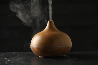 Siyah masasında buhar bulunan Aroma yağı yayıcı