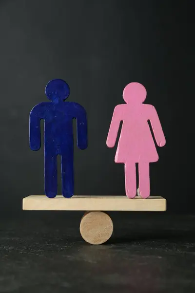 stock image Gender equality concept. Male and female figures on scales against grey background