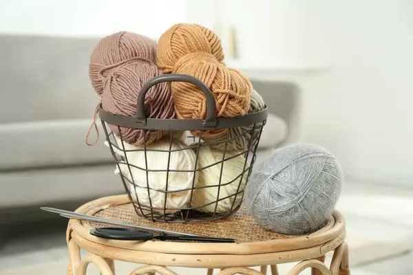 stock image Skeins of soft yarn, knitting needles and scissors on table indoors