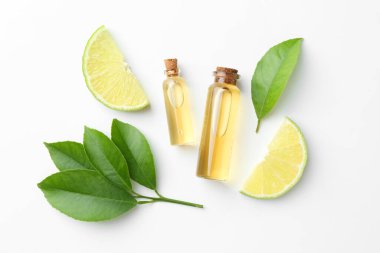 Beyaz arka planda gerekli yağlar, kireç ve yeşil yapraklar, düzlük