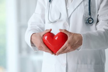 Klinikte kırmızı kalpli bir doktor, yakın plan.