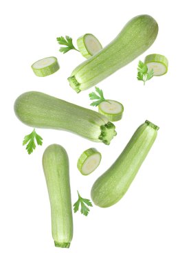 Beyaz arka plana düşen taze kabaklar ve maydanozlar.