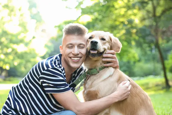 Parkta sevimli köpeğiyle genç bir adam.