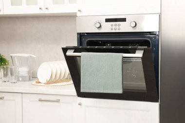 Mutfakta havluyla elektrikli fırını aç. Yemek pişirme aygıtı