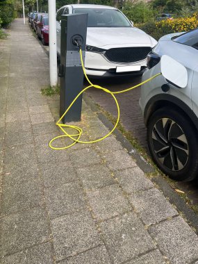 Dışarıdaki istasyondan modern elektrikli araba şarj ediliyor.