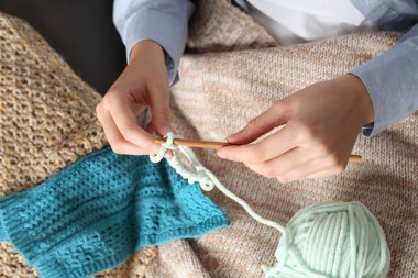 Kanca ve iplikle örgü ören kadın, üst manzara.