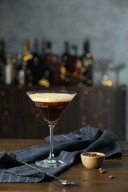 Ahşap masada taze kokteyl, kaşık ve kahve çekirdekleri.