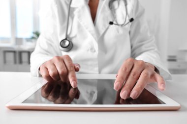 Klinikteki masada tabletli doktor, yakın çekim.