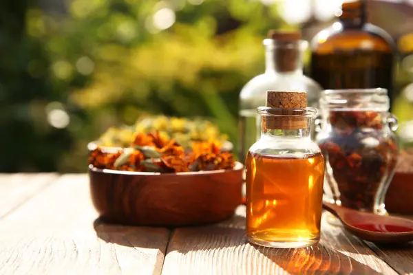 stock image Different tinctures and ingredients on wooden table outdoors