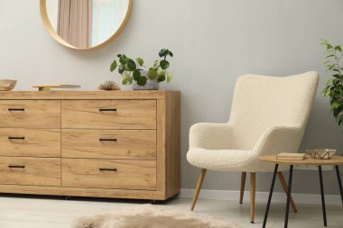 Açık gri duvardaki yuvarlak ayna. İç tasarım