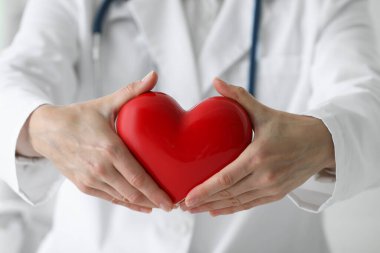 Klinikte kırmızı kalpli bir doktor, yakın plan.