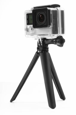 Beyaz arkaplanda modern aksiyon kamerası ve tripod