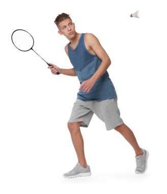 Beyaz arka planda raket ve kuş tüyü ile badminton oynayan genç adam.