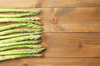 Taze yeşil kuşkonmaz, ahşap masa üzerinde, üst manzara. Metin için boşluk