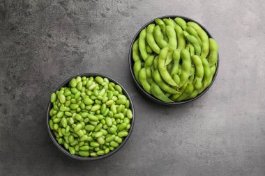 Çiğ yeşil edamame soya fasulyesi ve kapsülleri gri masada, üst manzara
