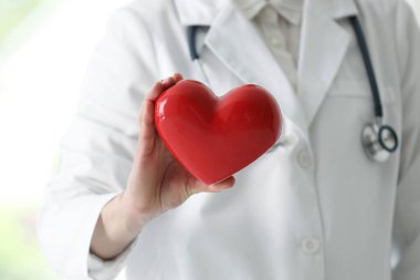 Klinikte kırmızı kalpli bir doktor, yakın plan.