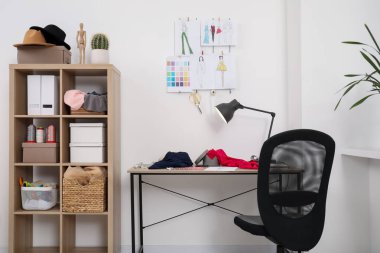 Moda tasarımcısının iş yeri. Yeni kıyafetler ve diğer malzemelerin çizimleri.