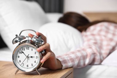 Kadın öğle yemeği saatinde yatak odasındaki çalar saati kapatıyor, seçici odaklanma