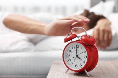 Adam öğle yemeği saatinde yatak odasındaki çalar saati kapatıyor, seçici odaklanma