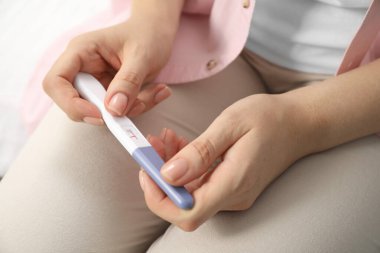Kapalı alanda hamilelik testi tutan kadın, yakın çekim.