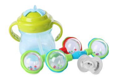 Renkli çıngıraklar, beyaz şişeler ve emzikler. Bebek eşyaları.
