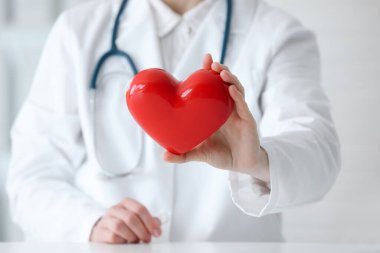 Klinikteki kırmızı kalpli doktor, yakın plan.