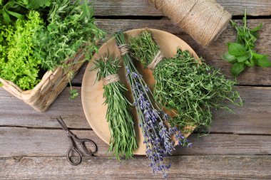 Farklı aromatik otlar ve makas ahşap masa, düz yatar