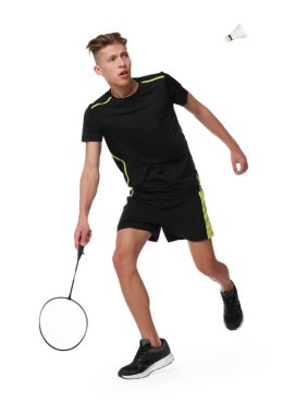 Beyaz arka planda raket ve kuş tüyü ile badminton oynayan genç adam.