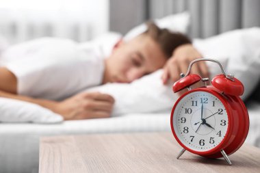 Yemek saatinde yatakta uyuyan adam, alarma odaklan.