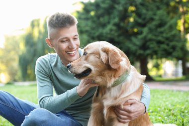 Parkta sevimli köpeğiyle genç bir adam.