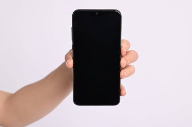 Beyaz arkaplanda boş ekranlı akıllı telefonu tutan kadın, yakın plan