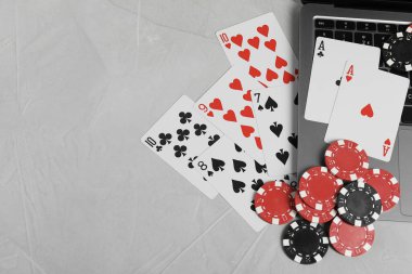 Çevrimiçi poker. Açık gri masada kart, fiş ve dizüstü bilgisayar oynuyoruz. Metin için boşluk