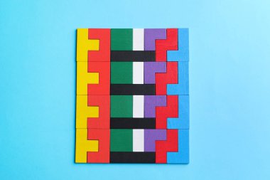 Açık mavi arkaplanda renkli ahşap yapboz parçaları, üst görünüm