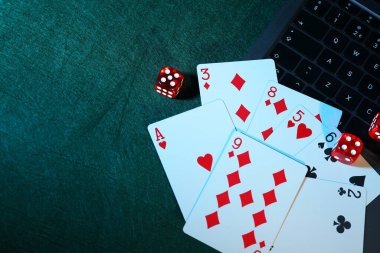 Çevrimiçi poker. Yeşil masada, yukarıdan oyun kartları, zarlar ve dizüstü bilgisayarlar. Metin için boşluk