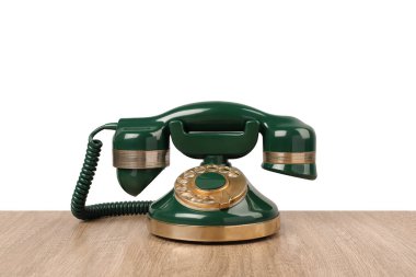Yeşil renkli telefon ahşap masada, arka planda ışık var.