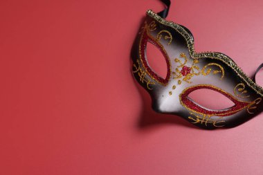 Kırmızı arka planda güzel bir karnaval maskesi, üst manzara. Metin için boşluk