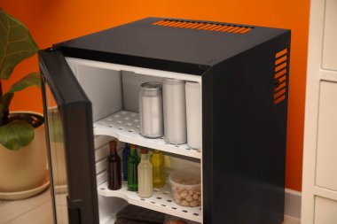 Farklı içecekler ve atıştırmalıklarla dolu mini buzdolabı.