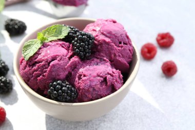 Delicious blackberry sorbet, mint and fresh berries on grey table, closeup. Space for text clipart