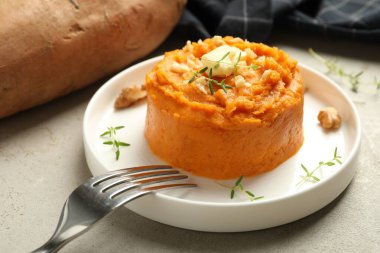 Lezzetli patates püresi, tereyağı, kekik ve ceviz. Gri desenli masa, yakın plan.