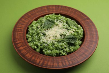 Açık yeşil arka planda parmesan peynirli lezzetli ıspanaklı risotto.