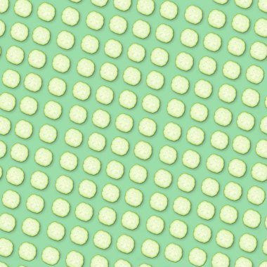 Yeşil zemin üzerinde yuvarlak salatalık dilimleri, desen tasarımı