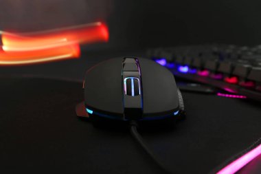 Koyu arkaplanda bilgisayar faresi ve RGB klavyesi, yakın plan